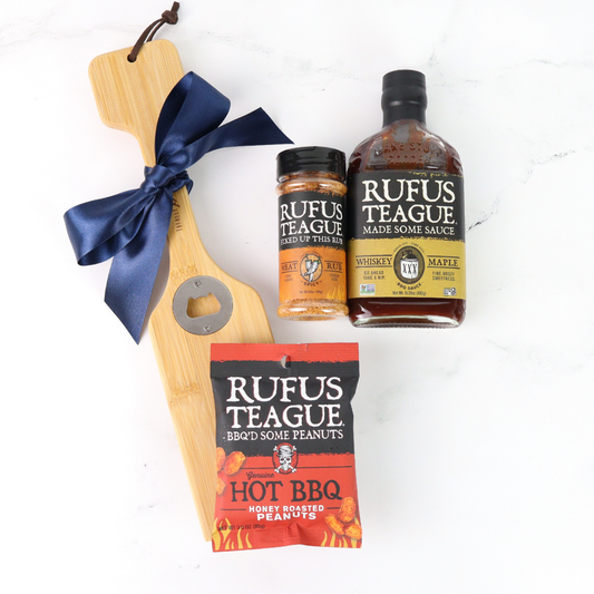 Gourmet gift set with Rufus Teague products including a bottle, jar, and package on a white background.