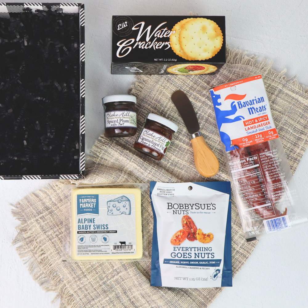 Assorted food items including crackers, meats, and cheese on a textured surface.
