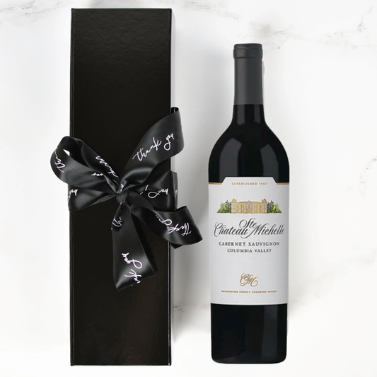 Chateau Ste. Michelle wine bottle with a black gift box and ribbon on a white background