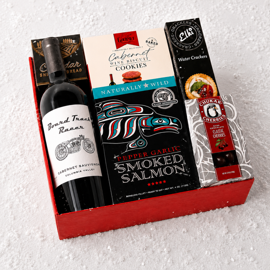 A curated gift box set containing a bottle of Beard Trees Racing Cabernet Sauvignon, a box of Lucky Cabernet Wine Biscuit Cookies, Pepper Garlic Smoked Salmon crackers, and a box of Water Crackers, all arranged in a red gift box on a white textured background.